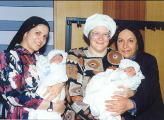 Yad Letinok volunteers holding twin babies.